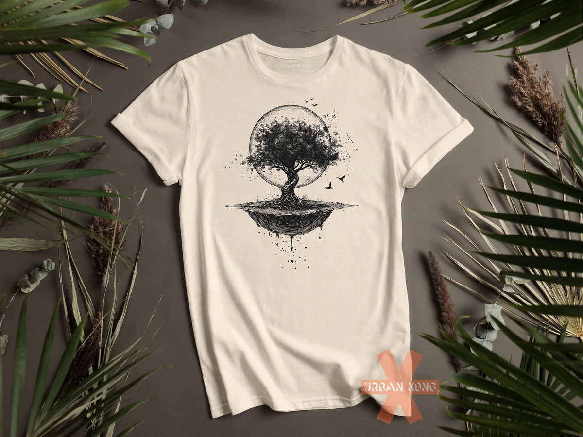 White t-shirt with a tree design on a gray surface with green leaves