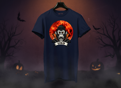 Navy blue t-shirt with a graphic design of a monkey and 'UKO' text on a hanger against a Halloween-themed background.