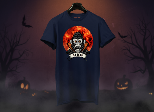 Navy blue t-shirt with a graphic design of a monkey and 'UKO' text on a hanger against a Halloween-themed background.