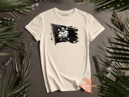 White t-shirt with graphic design on a gray surface with green leaves