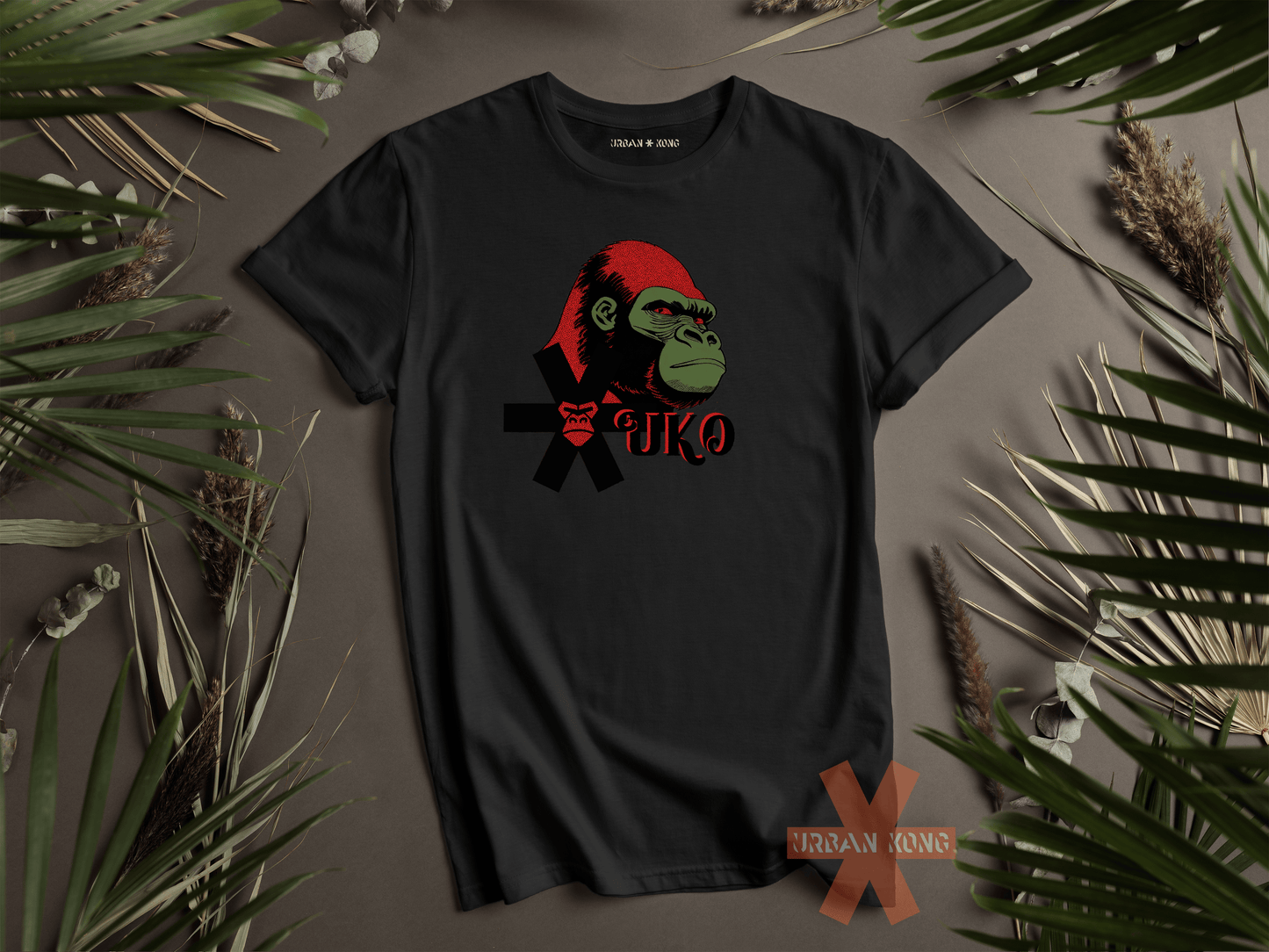 Black t-shirt with a graphic design of a monkey wearing a Santa hat on a brown background with green leaves.