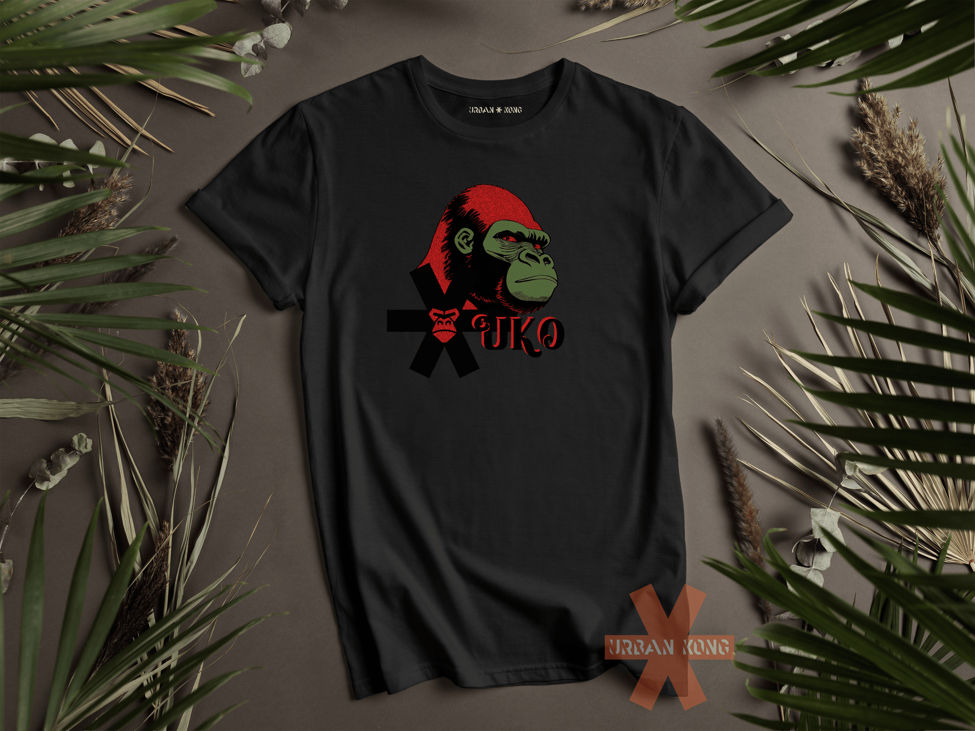 Black t-shirt with a graphic design of a monkey wearing a Santa hat on a brown background with green leaves.