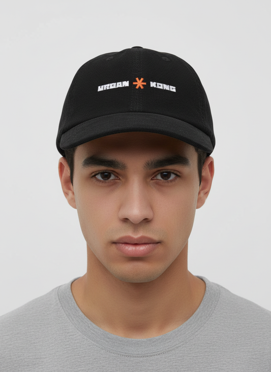 Person wearing a black cap with branding on a plain background