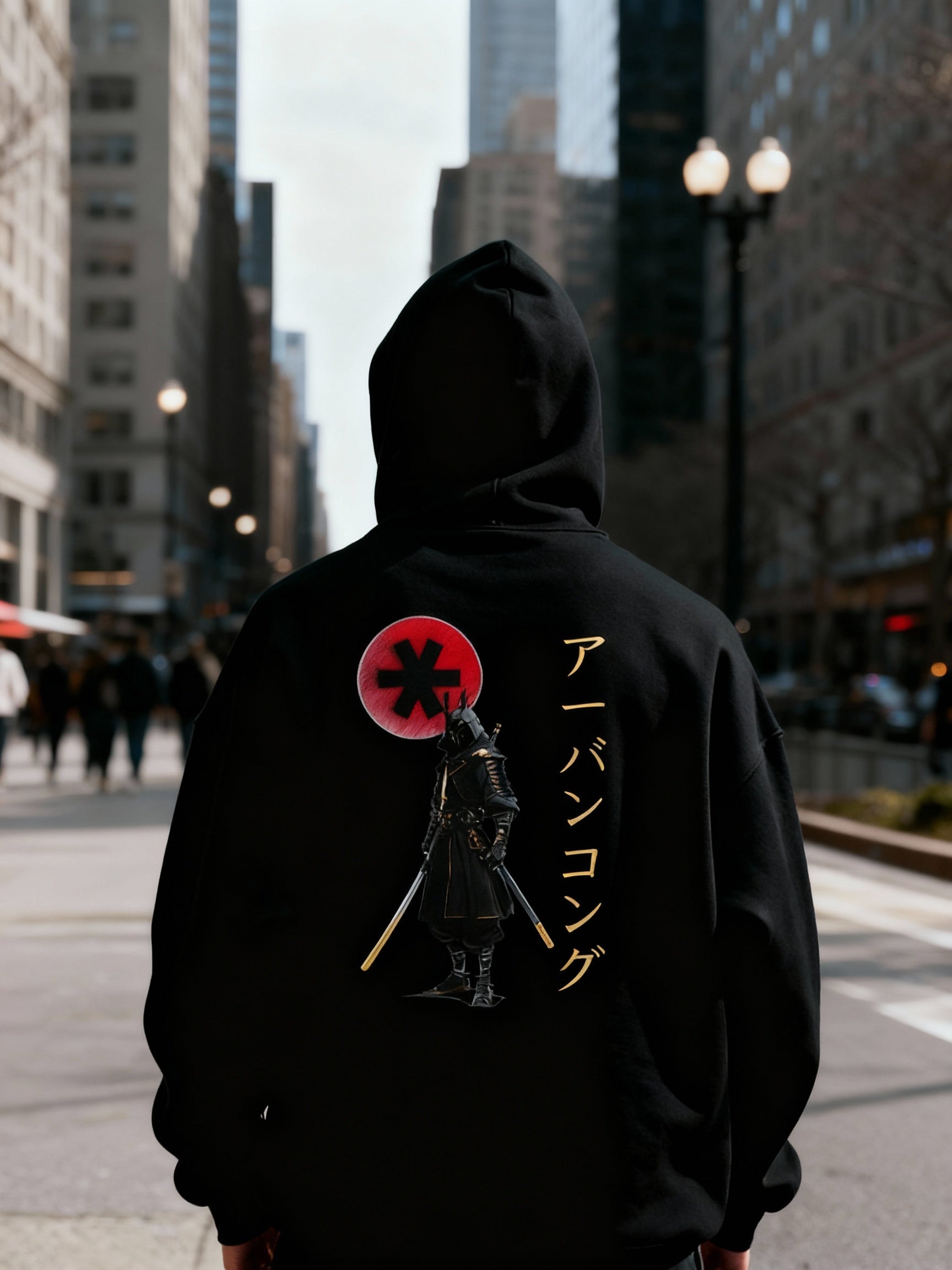 Person wearing a black hoodie with a graphic design on the back in an urban setting