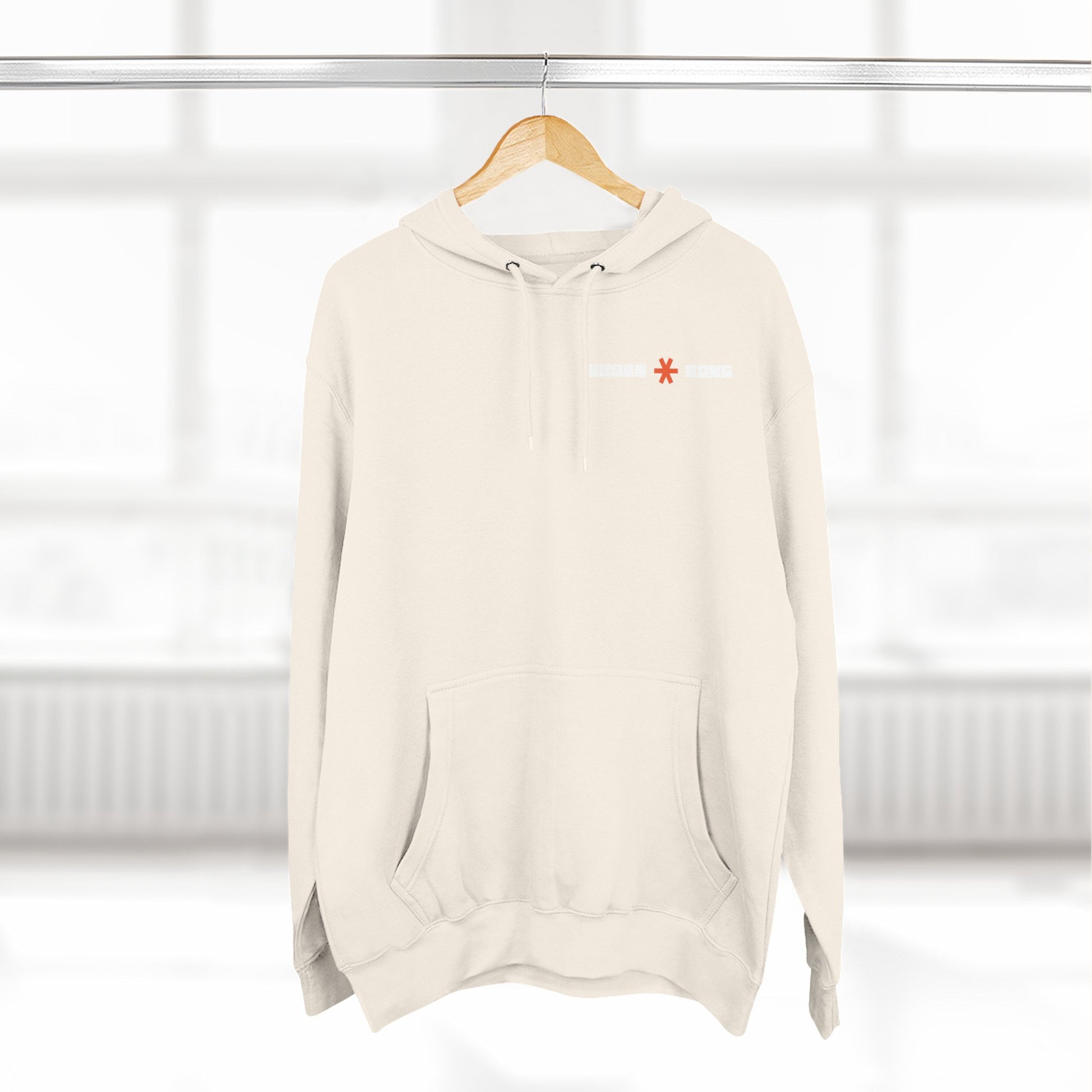 Beige hoodie with a red logo on a hanger against a white background