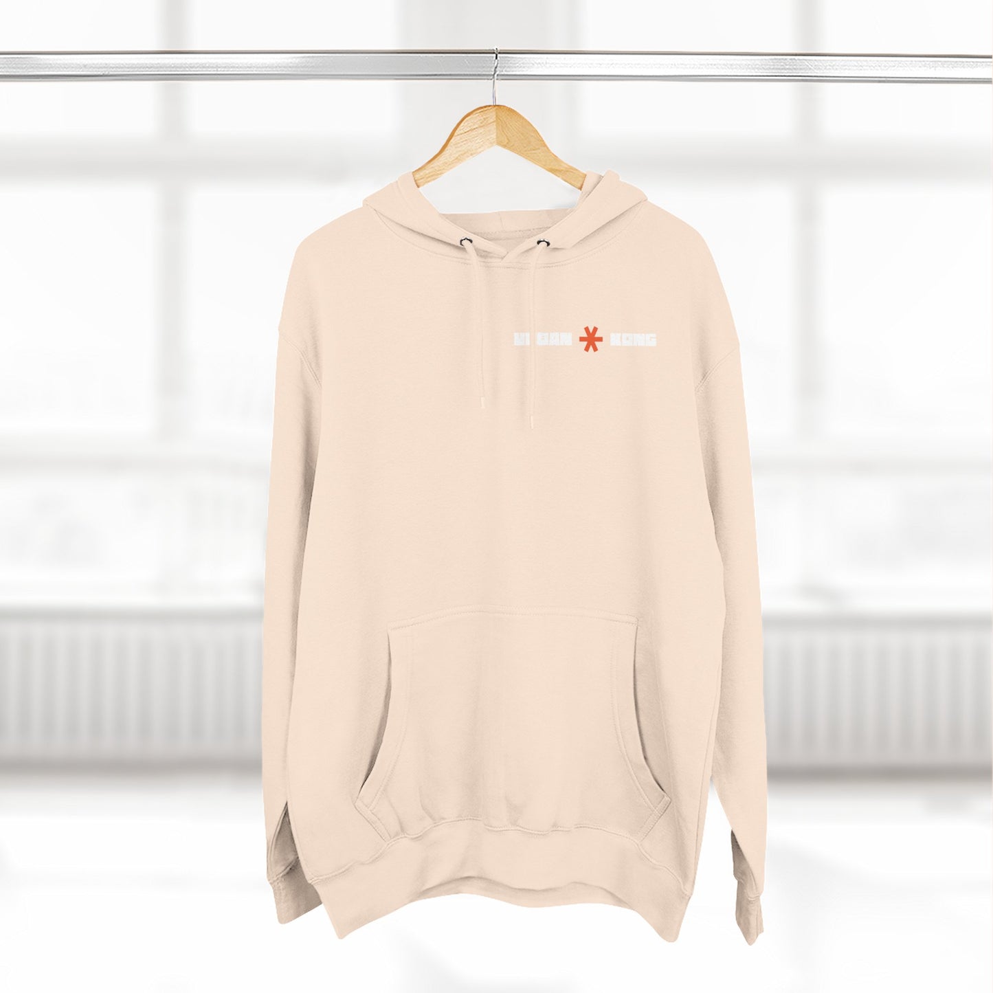 Beige hoodie with a logo on a hanger against a white background