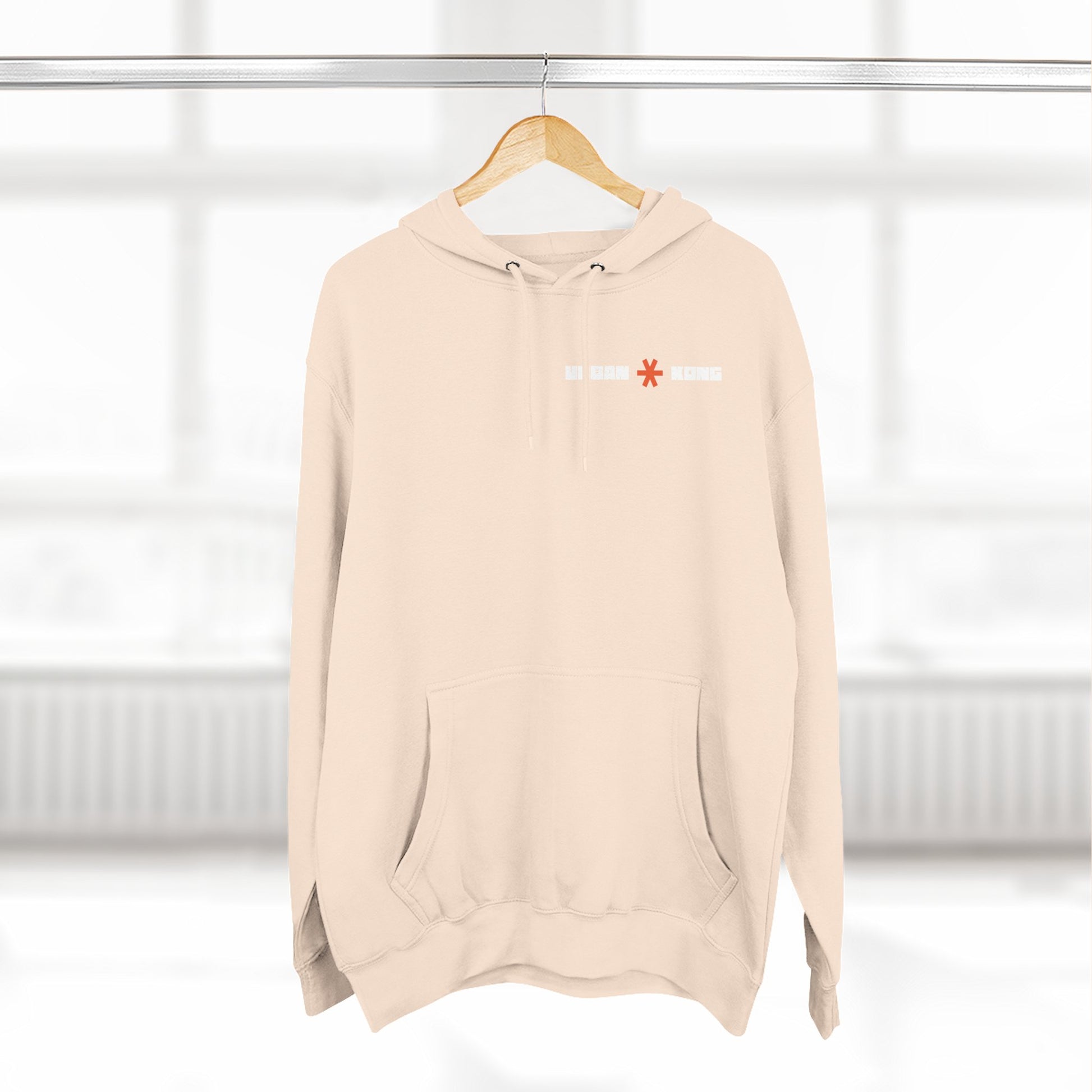 Beige hoodie with a logo on a hanger against a white background